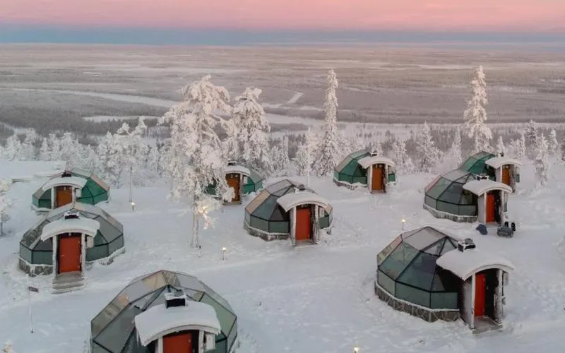 Glass igloos among snow-covered spruces on Utsuvaara fell at Golden Crown - Levin Iglut